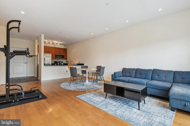 living area featuring recessed lighting, light wood-style flooring, and baseboards