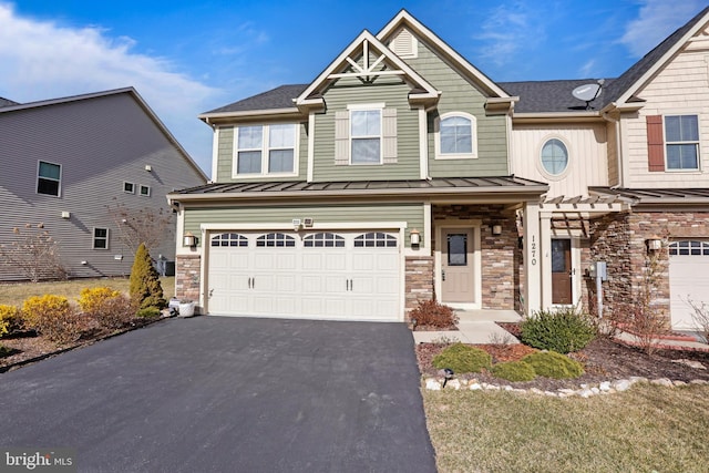 craftsman-style home with a standing seam roof, metal roof, a garage, stone siding, and driveway