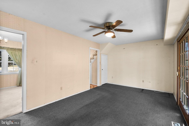 carpeted empty room with a ceiling fan, visible vents, and wallpapered walls