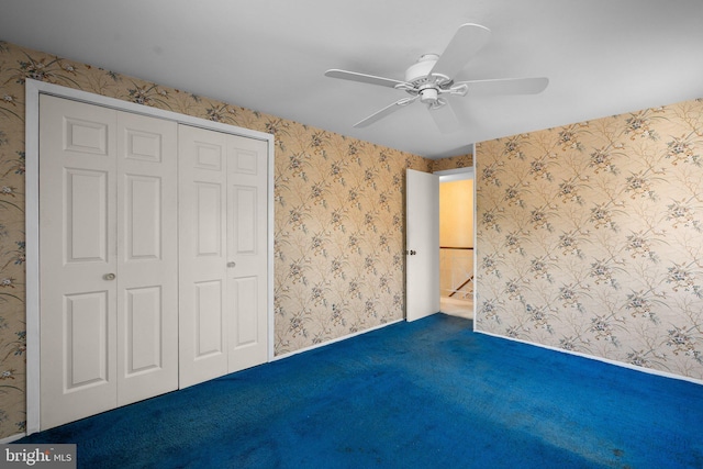 unfurnished bedroom featuring wallpapered walls, baseboards, ceiling fan, carpet, and a closet