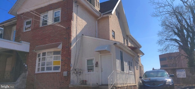 view of property exterior featuring brick siding and stucco siding