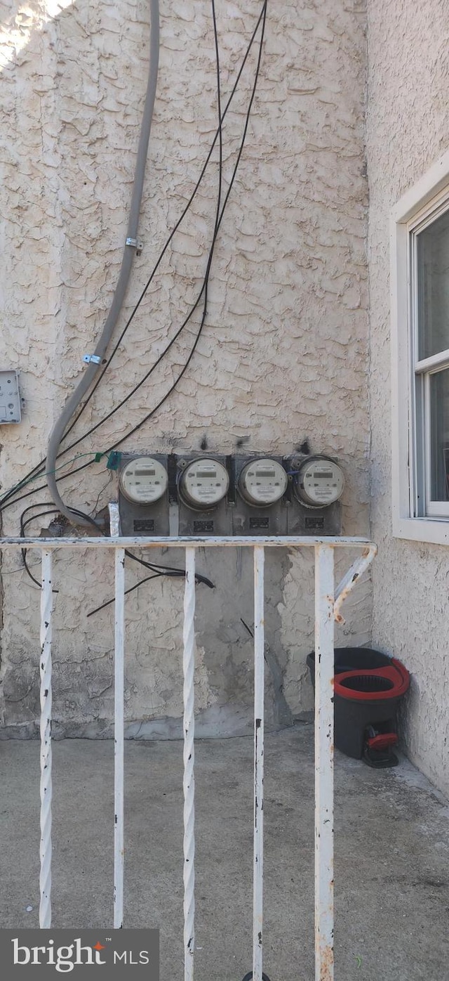 details featuring stucco siding and electric meter