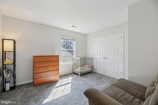 carpeted bedroom featuring baseboards, visible vents, and a closet