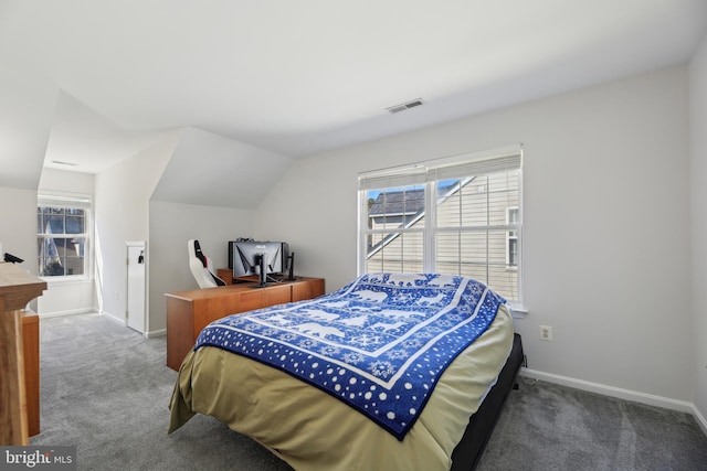 carpeted bedroom with lofted ceiling, visible vents, and baseboards