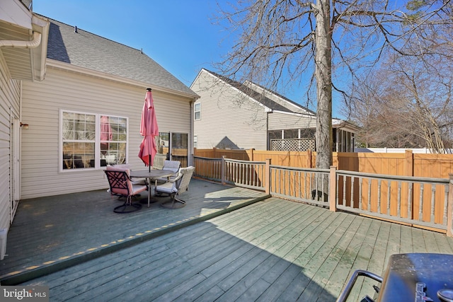 wooden terrace featuring outdoor dining space and fence