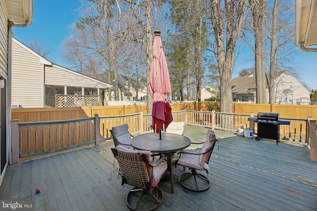 deck featuring outdoor dining area, a fenced backyard, and grilling area