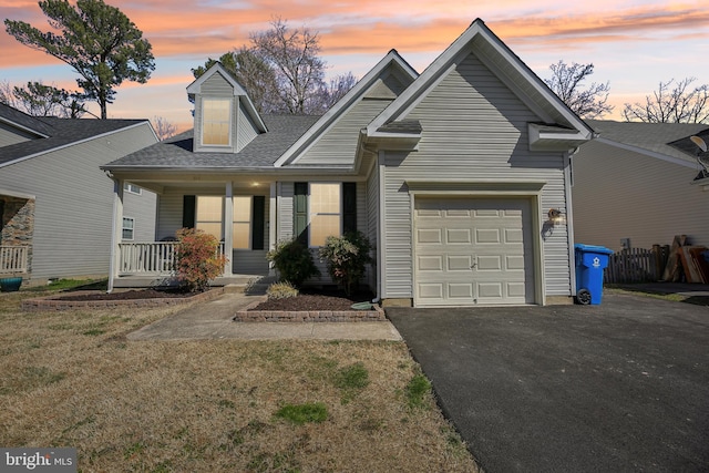 view of front facade featuring aphalt driveway, a porch, a lawn, fence, and a garage