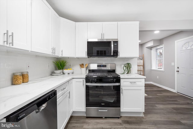 kitchen with stainless steel appliances, dark wood-style flooring, white cabinetry, backsplash, and light stone countertops