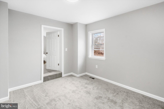 unfurnished bedroom with light carpet, visible vents, and baseboards