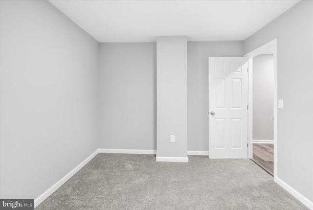 unfurnished bedroom featuring light carpet and baseboards