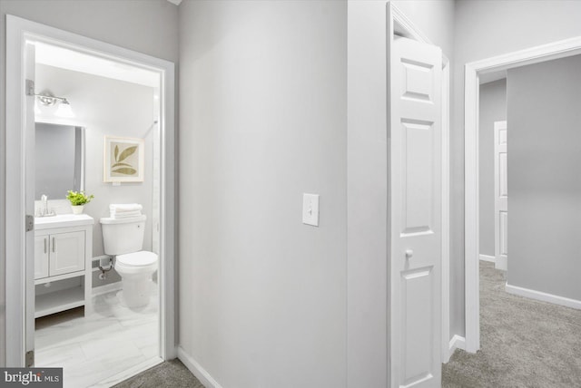 bathroom with toilet, baseboards, and vanity