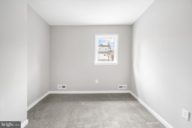 carpeted spare room featuring baseboards and visible vents