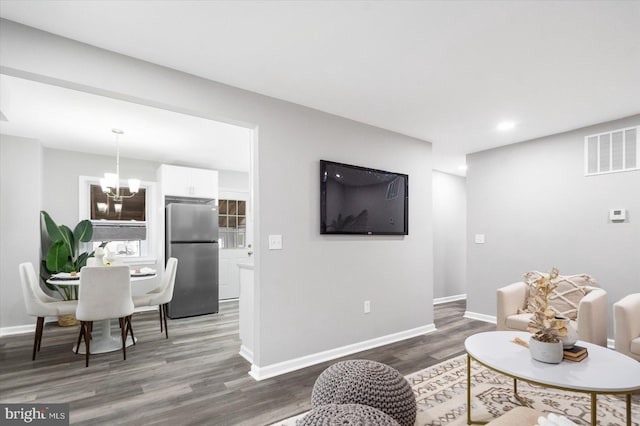 living room with baseboards, visible vents, wood finished floors, a chandelier, and recessed lighting