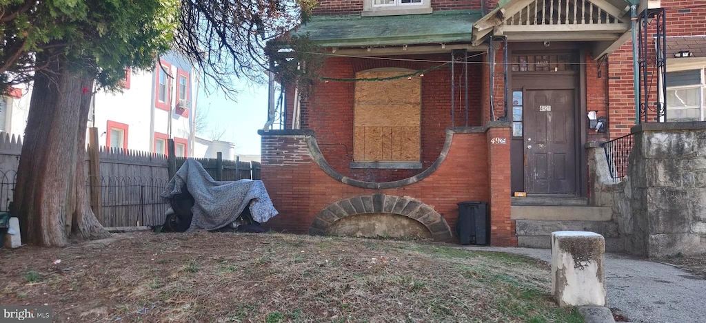 exterior space featuring brick siding and fence