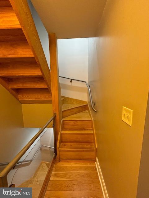 staircase with baseboards and wood finished floors