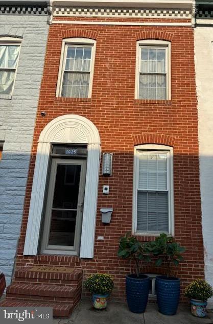 doorway to property featuring brick siding