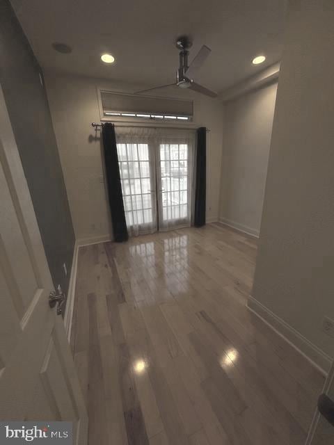 spare room featuring recessed lighting, baseboards, and wood finished floors