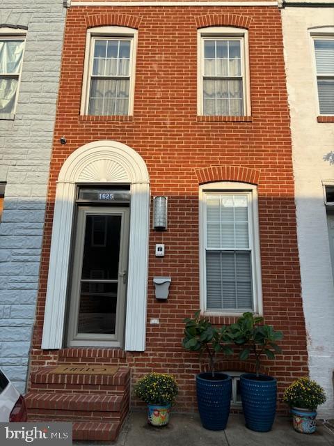 entrance to property featuring brick siding