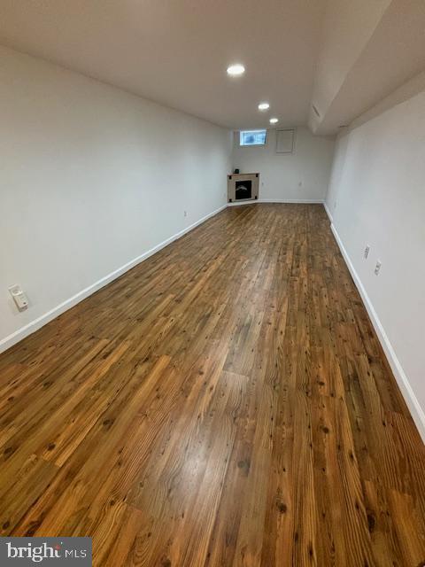 interior space featuring dark wood-style floors, recessed lighting, a fireplace, and baseboards