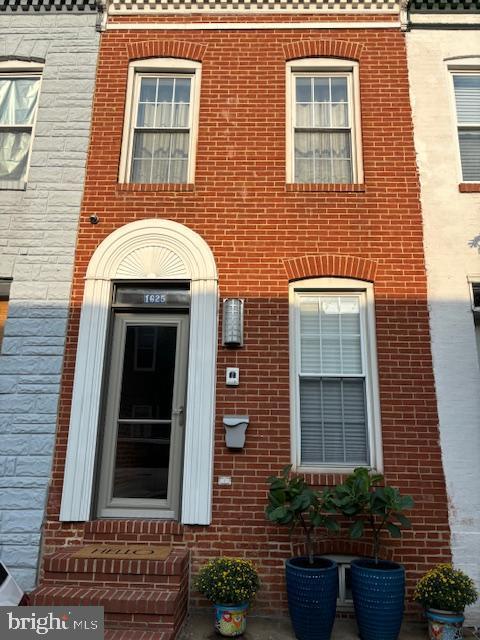 doorway to property with brick siding