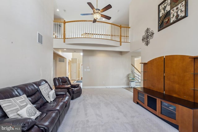 living area with carpet, stairs, visible vents, and baseboards