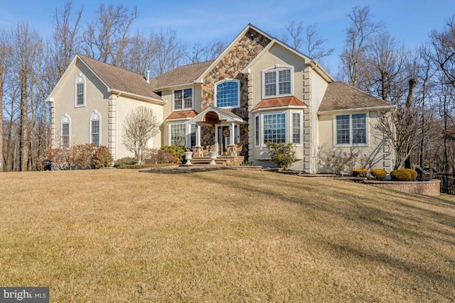 traditional-style house featuring stone siding, a front lawn, and stucco siding