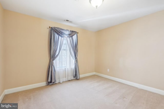 carpeted empty room with visible vents and baseboards