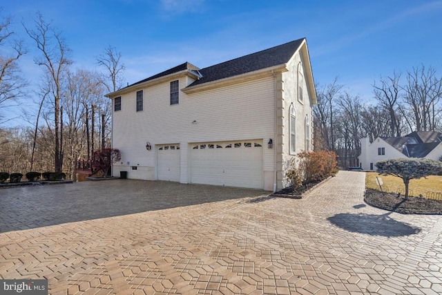 view of home's exterior featuring a garage and decorative driveway