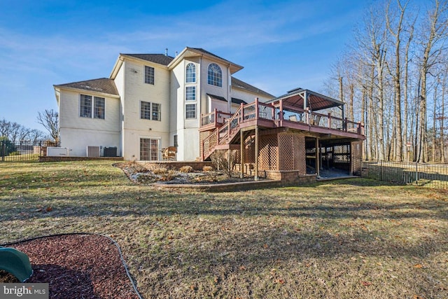 rear view of property featuring stairs, fence, a lawn, and a wooden deck