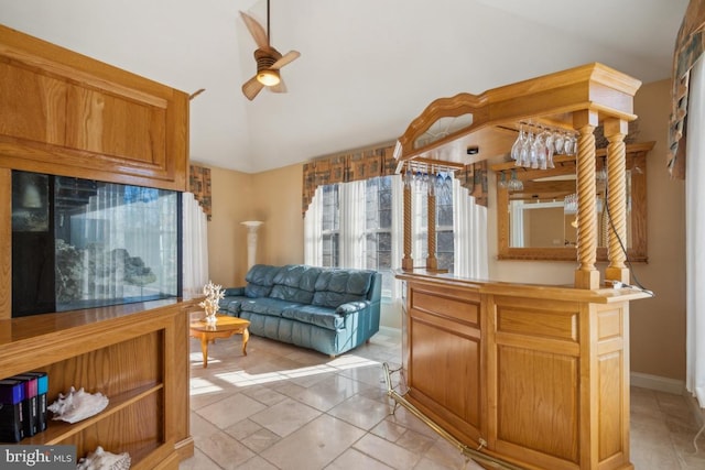 interior space featuring ceiling fan, open floor plan, lofted ceiling, and baseboards