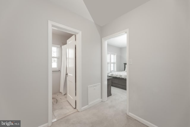 hallway with light carpet and baseboards