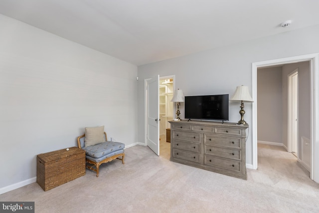 sitting room featuring baseboards and light colored carpet