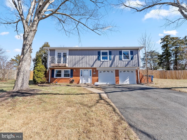 view of front facade featuring driveway, a garage, fence, and brick siding