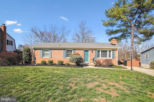 single story home featuring brick siding, a front lawn, and a chimney