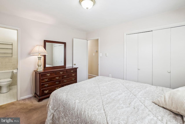 carpeted bedroom featuring baseboards, a closet, and ensuite bathroom