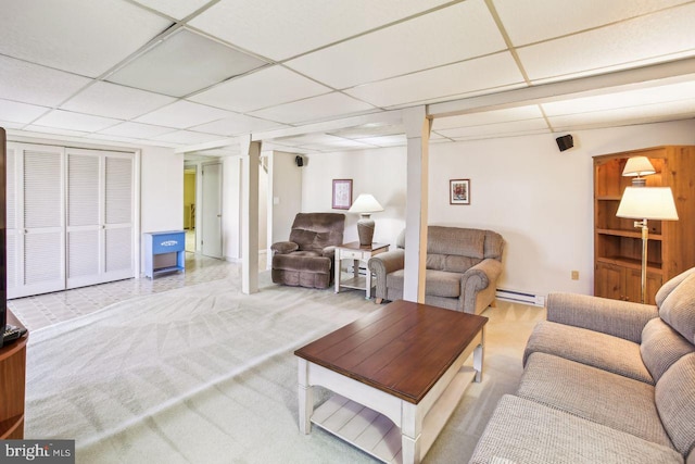 living room with a drop ceiling and a baseboard radiator