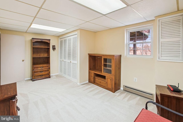 sitting room with baseboard heating, carpet flooring, and a drop ceiling