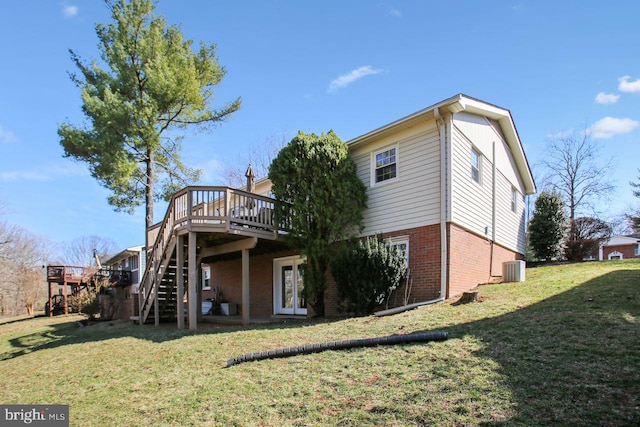 back of house featuring brick siding, stairway, a wooden deck, cooling unit, and a yard