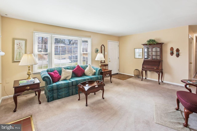 living area with light colored carpet and baseboards