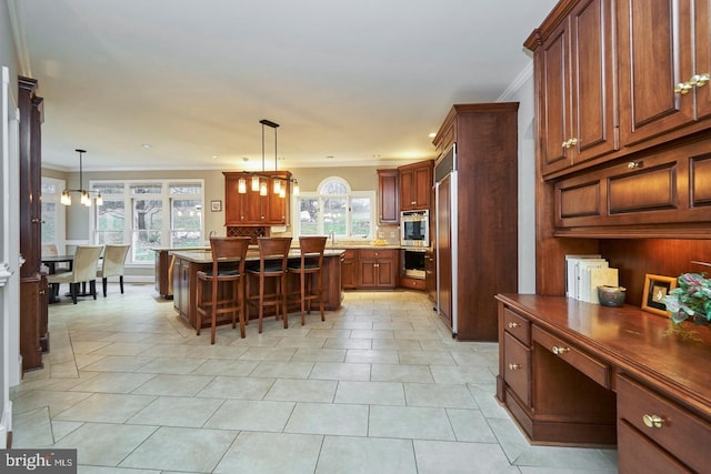 kitchen featuring decorative backsplash, a breakfast bar area, a healthy amount of sunlight, and ornamental molding