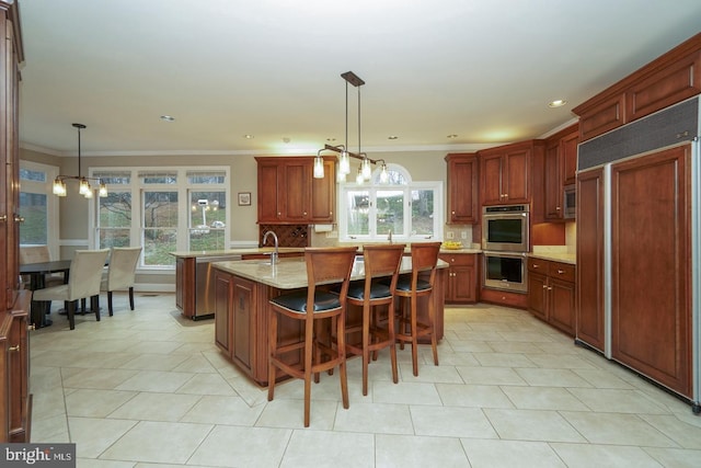 kitchen featuring stainless steel appliances, tasteful backsplash, a kitchen island with sink, and crown molding