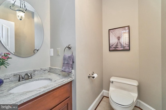 bathroom featuring baseboards, toilet, vanity, and tile patterned flooring