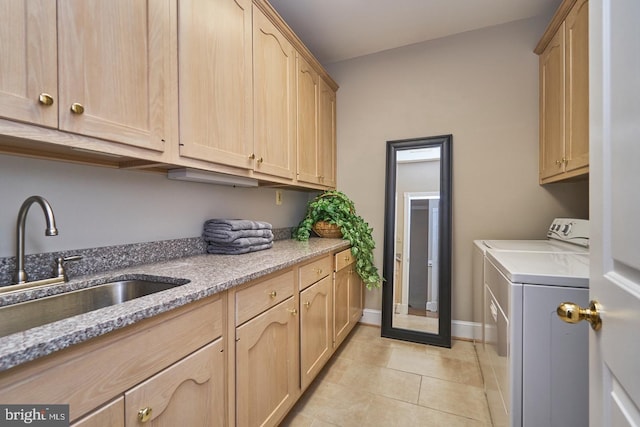 clothes washing area featuring light tile patterned floors, baseboards, cabinet space, a sink, and washer and dryer