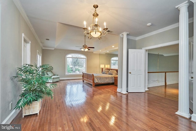 unfurnished bedroom featuring crown molding, decorative columns, wood finished floors, and baseboards