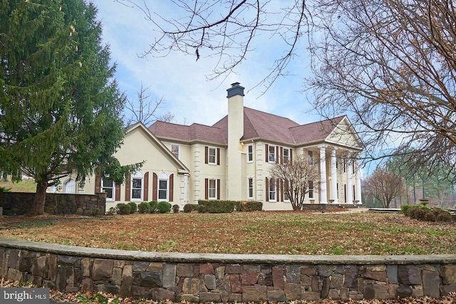 view of front of property featuring stucco siding and a chimney