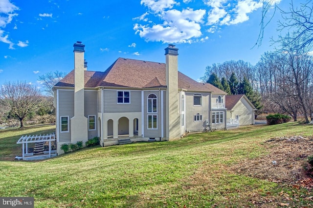 rear view of property featuring a lawn and a chimney