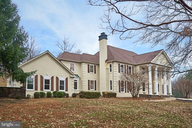 view of front of house featuring stucco siding and a chimney