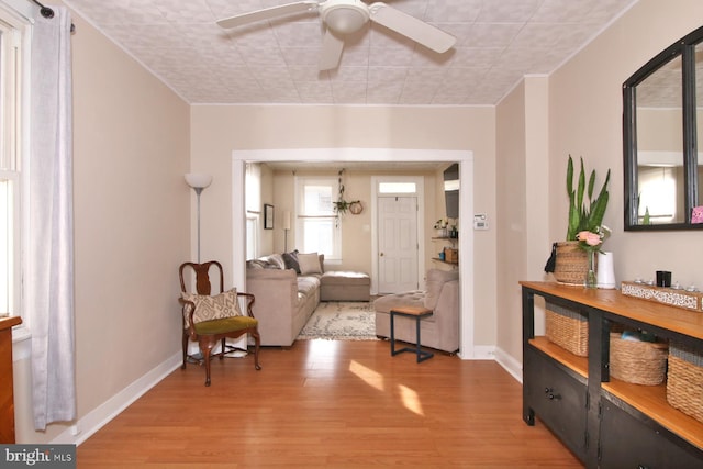 sitting room featuring ceiling fan, wood finished floors, and baseboards