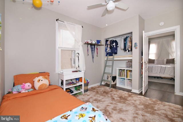 bedroom with dark wood-type flooring, a closet, multiple windows, and baseboards