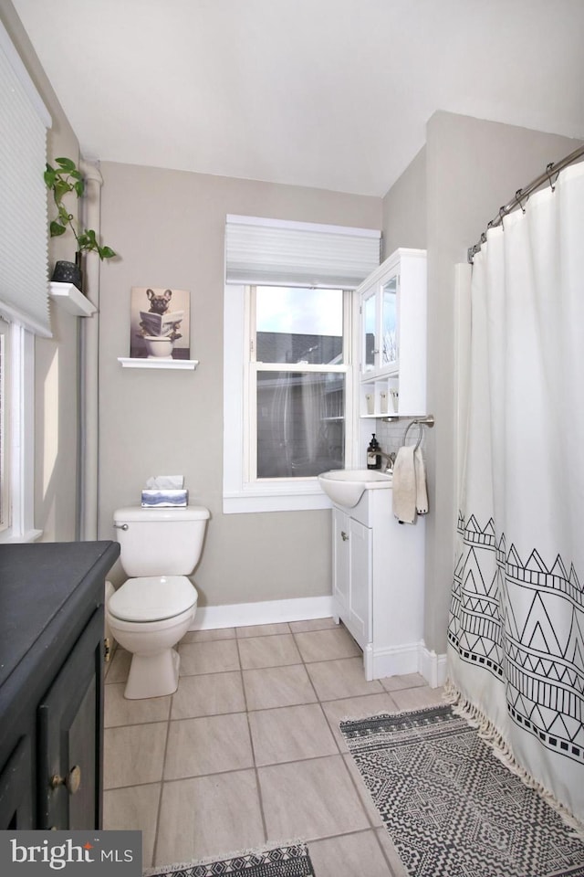 full bathroom with toilet, tile patterned flooring, baseboards, and vanity